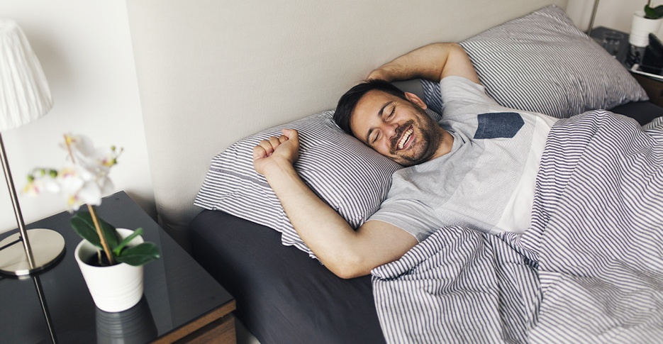 Man waking feeling rested thanks to Herbst oral appliance treatment