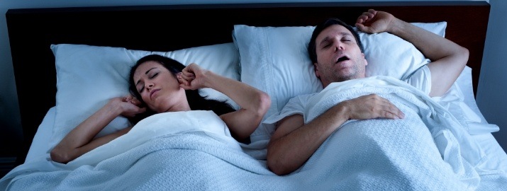 Frustrated woman next to snoring man in need of sleep apnea therapy