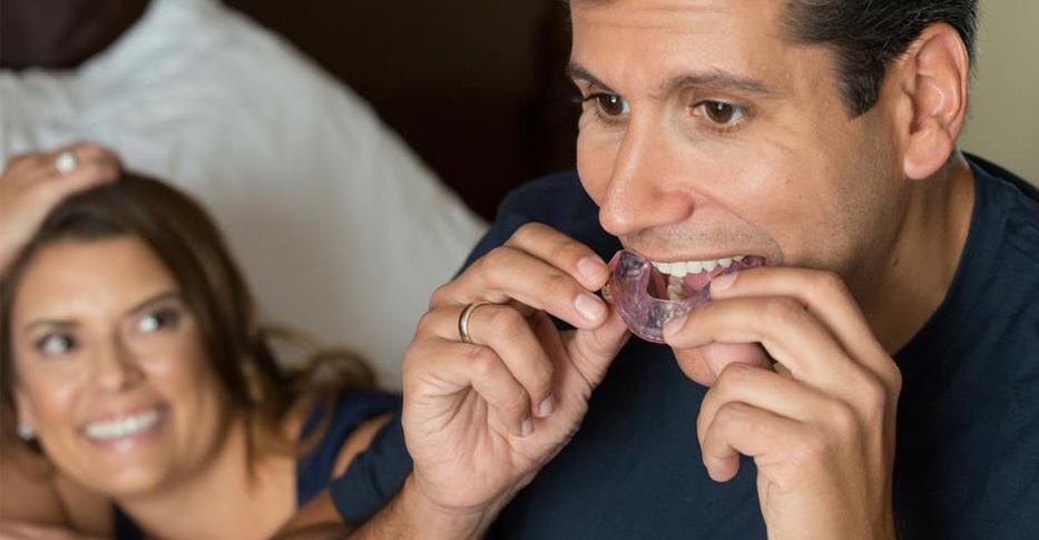 Man placing CPAP alternative oral appliance for sleep apnea