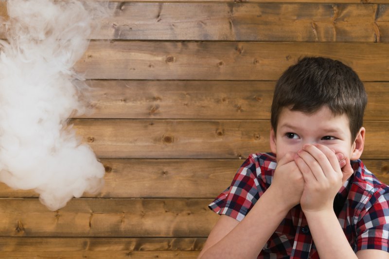 Child covering mouth to avoid secondhand smoke