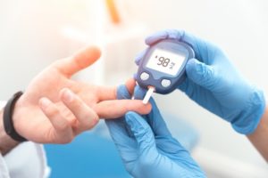 medical professional checking a person’s blood sugar 