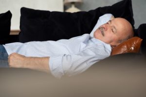 man on a couch napping without sleep apnea treatment