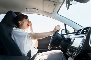 Woman with sleep apnea yawning while driving