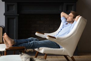 Young man sleeping in a white recliner
