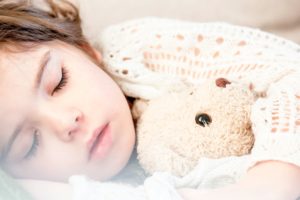 Sleeping child hugging a stuffed animal