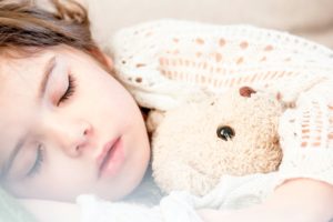 Sleeping child hugging a stuffed animal