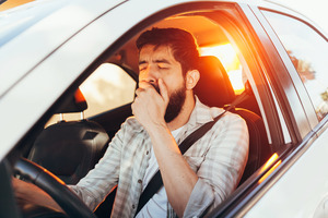 Man yawning in driver’s seat of the car